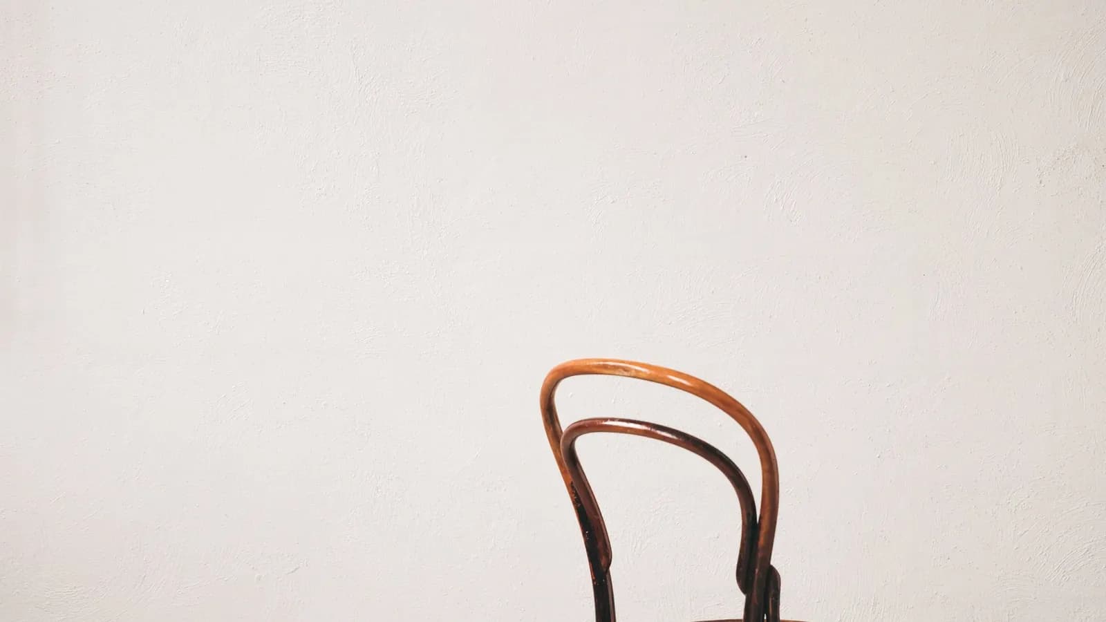 A wooden chair against a plain studio wall.