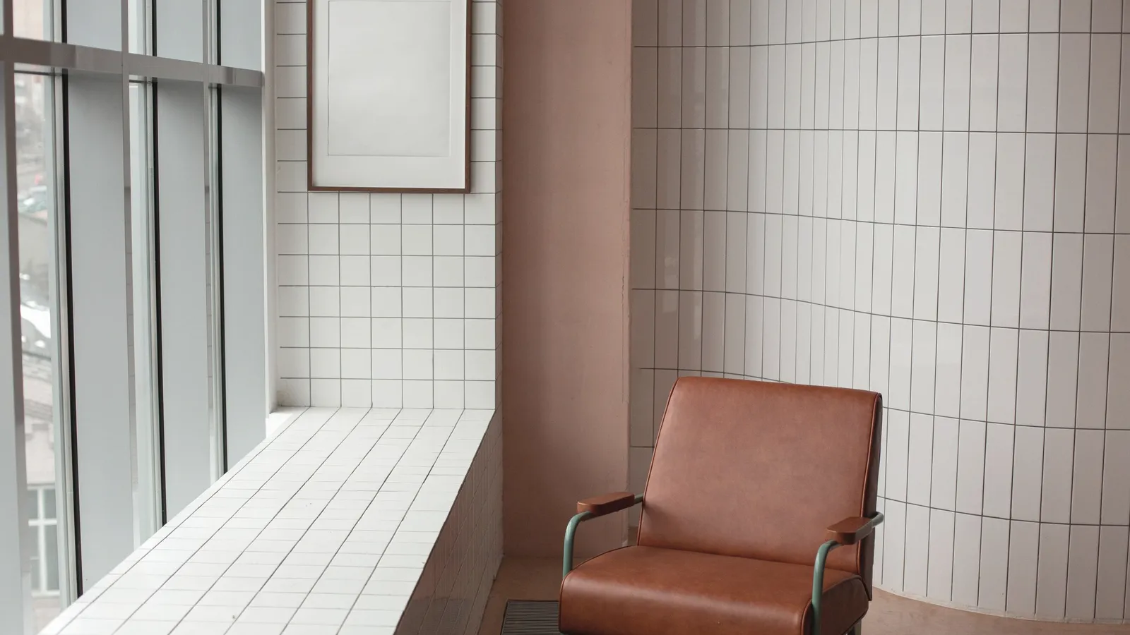 An armchair beside a window and a bare windowsill.