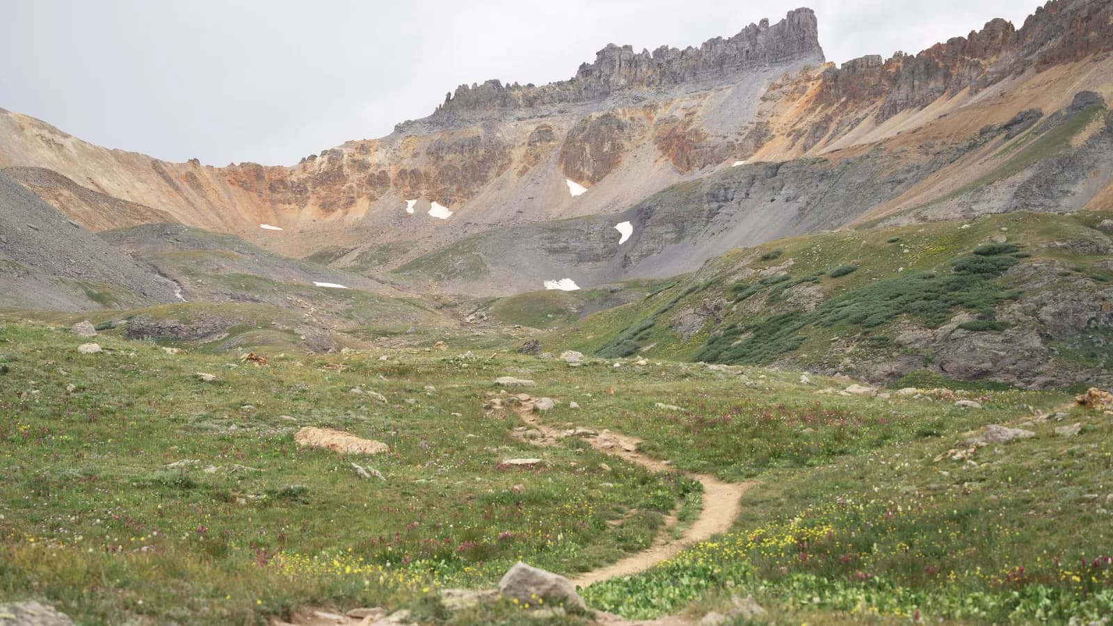 A footpath curving through a wide high basin at dawn.
