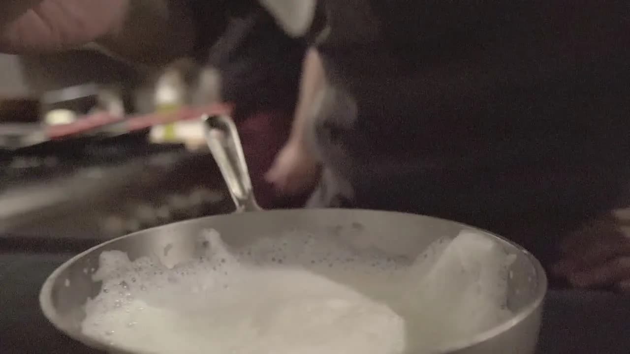 A dessert being finished by hand at the pass.