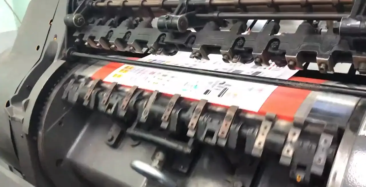 The ink rollers of a letterpress turning across the bed.